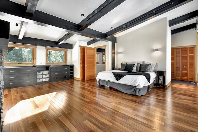 bedroom featuring dark wood-type flooring and beamed ceiling