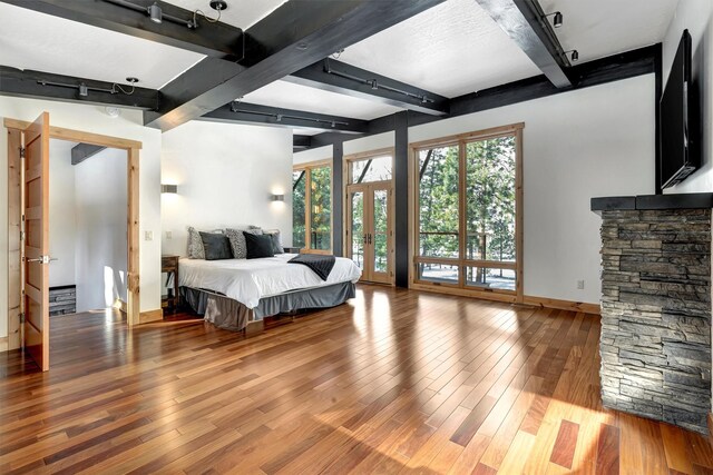1180 Reardon Ln, Alberton, MT 59820 - bedroom with beam ceiling, wood finished floors, baseboards, and french doors