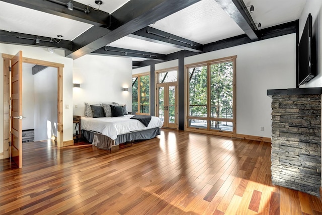 bedroom featuring wood-type flooring, french doors, and beamed ceiling