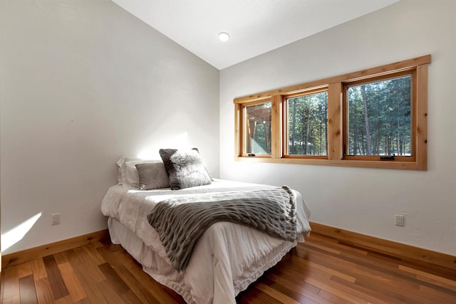 bedroom featuring dark wood-type flooring and vaulted ceiling