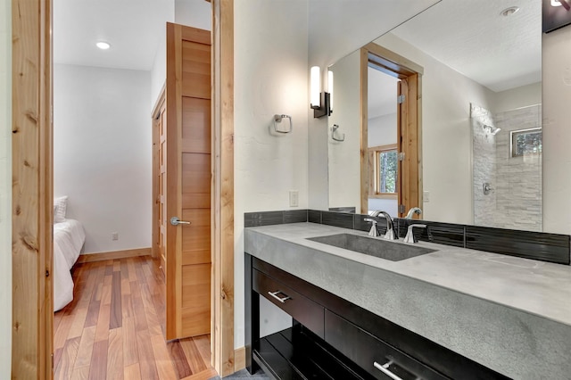 bathroom with wood-type flooring, a shower with door, and vanity