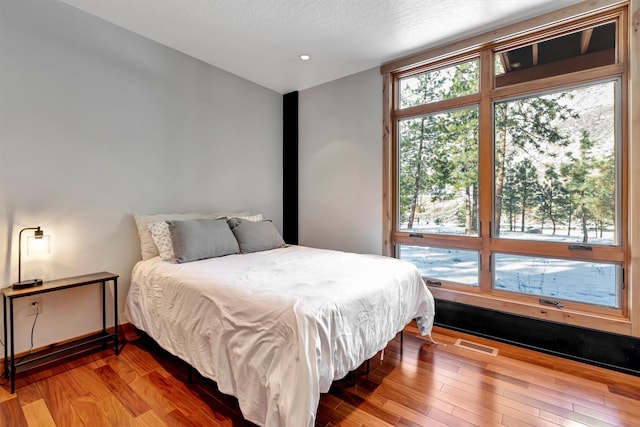 bedroom featuring wood-type flooring and a textured ceiling