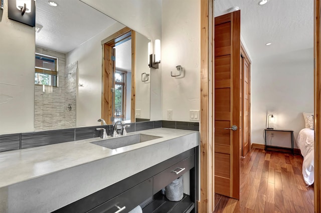 bathroom featuring wood-type flooring, vanity, and a textured ceiling