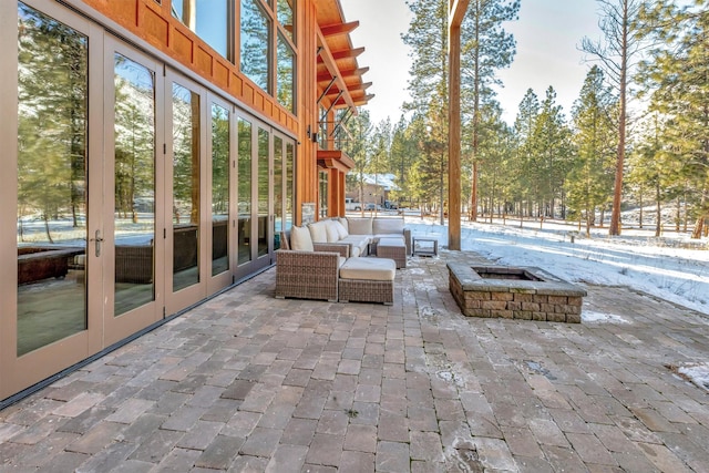 view of patio featuring an outdoor living space with a fire pit and french doors