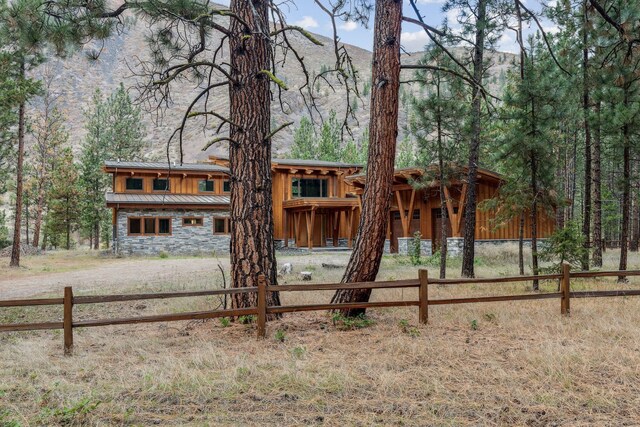 1180 Reardon Ln, Alberton, MT 59820 - chalet / cabin featuring a standing seam roof, stone siding, metal roof, and a forest view