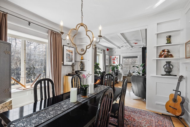 dining area with radiator heating unit, a wealth of natural light, a chandelier, and light wood-type flooring