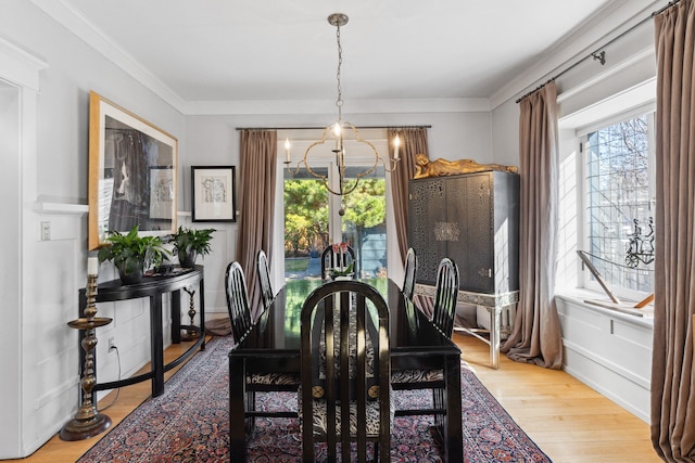 dining room featuring a notable chandelier, hardwood / wood-style flooring, and ornamental molding