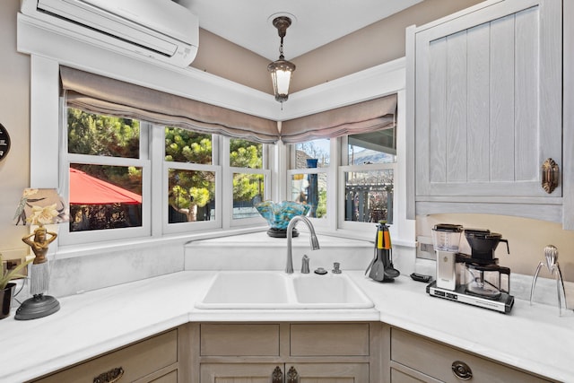 kitchen featuring sink, a wall mounted air conditioner, and decorative light fixtures