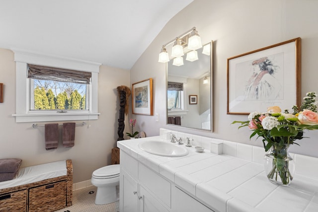 bathroom with tile patterned floors, lofted ceiling, toilet, and vanity