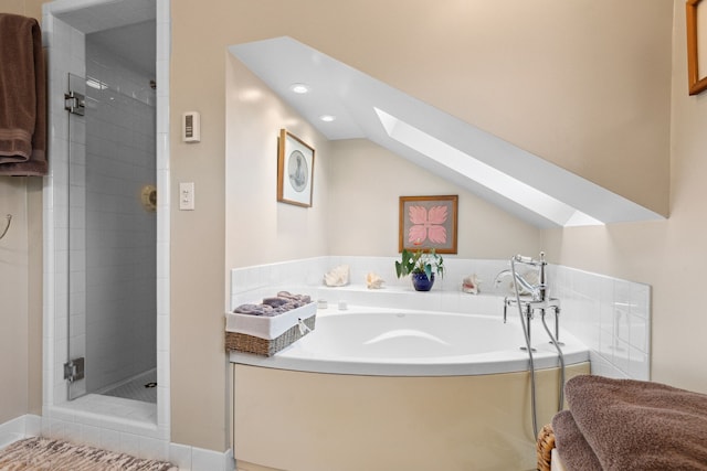 bathroom featuring independent shower and bath and vaulted ceiling with skylight