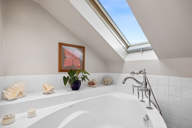 bathroom with lofted ceiling with skylight and a bathing tub