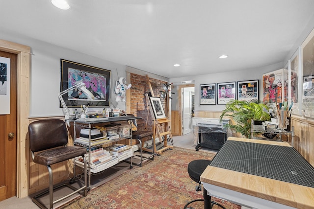 home office with carpet and wood walls