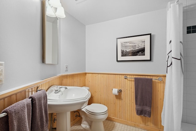 bathroom with a shower with curtain, wood walls, and toilet