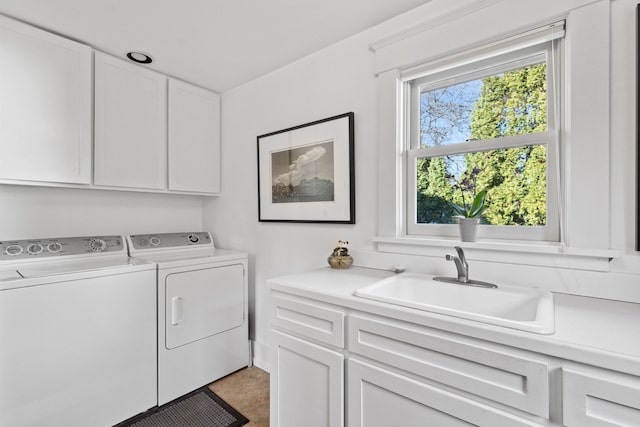 clothes washing area with independent washer and dryer, cabinets, and sink