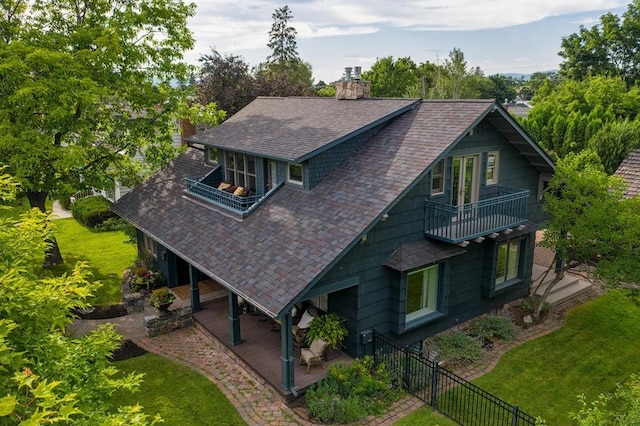 rear view of house with a yard and a balcony