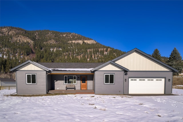 ranch-style home featuring a porch, a mountain view, and a garage