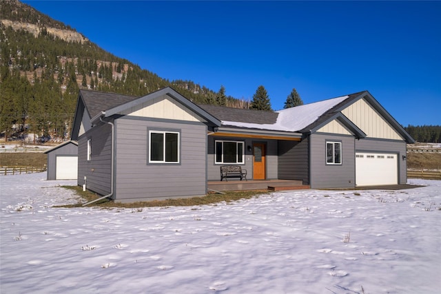 ranch-style home with a porch, a garage, and a mountain view