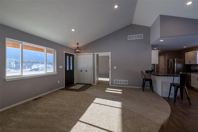 carpeted living room featuring lofted ceiling