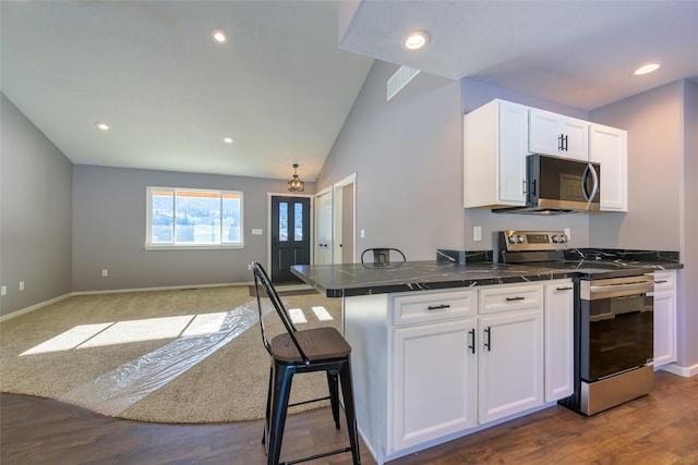 kitchen featuring appliances with stainless steel finishes, a breakfast bar area, white cabinets, and kitchen peninsula