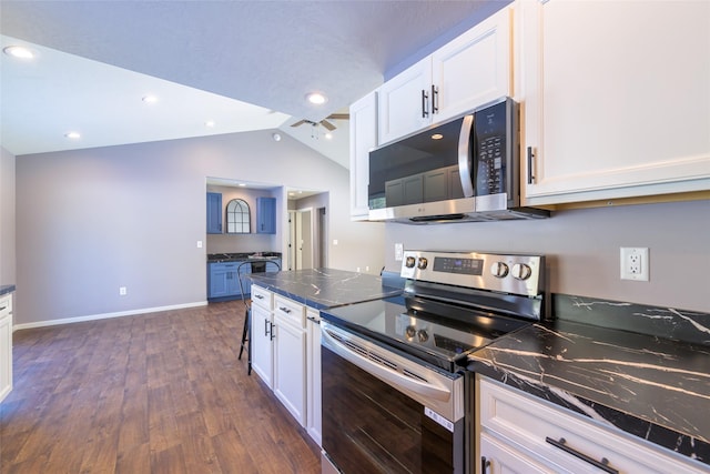 kitchen with stainless steel appliances, vaulted ceiling, white cabinets, and dark hardwood / wood-style flooring