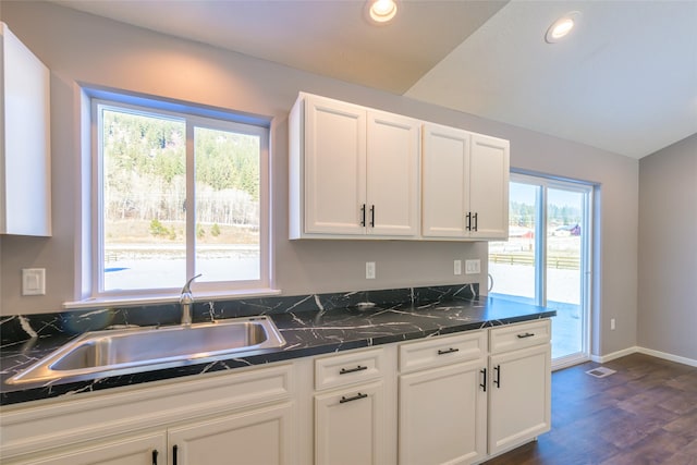 kitchen with vaulted ceiling, dark hardwood / wood-style floors, sink, and white cabinets