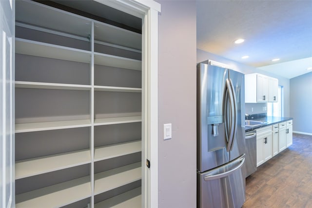 kitchen with white cabinetry, sink, dark hardwood / wood-style flooring, and appliances with stainless steel finishes