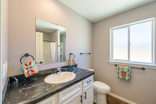 bathroom featuring vanity, curtained shower, wood-type flooring, and toilet