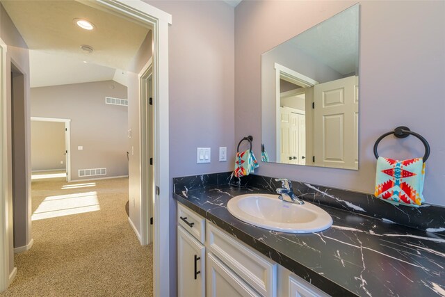 bathroom with vanity and lofted ceiling