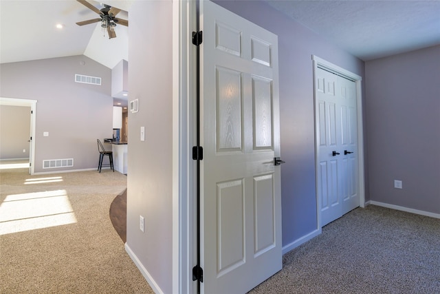 hall with lofted ceiling and carpet floors