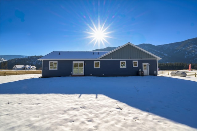 snow covered rear of property with a mountain view