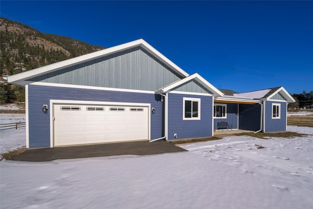 view of front of house featuring a mountain view, a garage, and covered porch