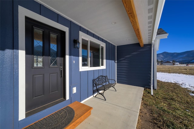 doorway to property featuring a mountain view and covered porch