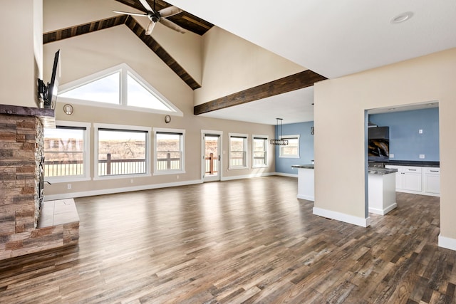 unfurnished living room with ceiling fan, high vaulted ceiling, and dark hardwood / wood-style flooring