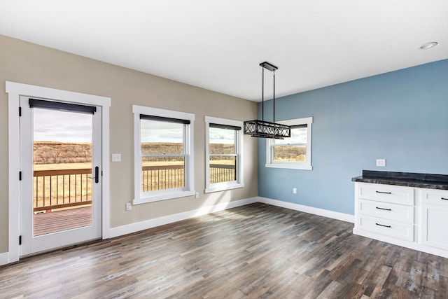 unfurnished dining area featuring dark wood-type flooring