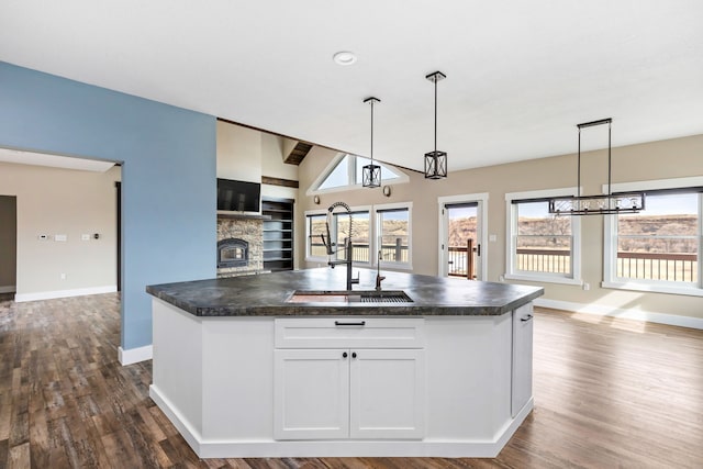 kitchen featuring pendant lighting, sink, a kitchen island with sink, and white cabinets