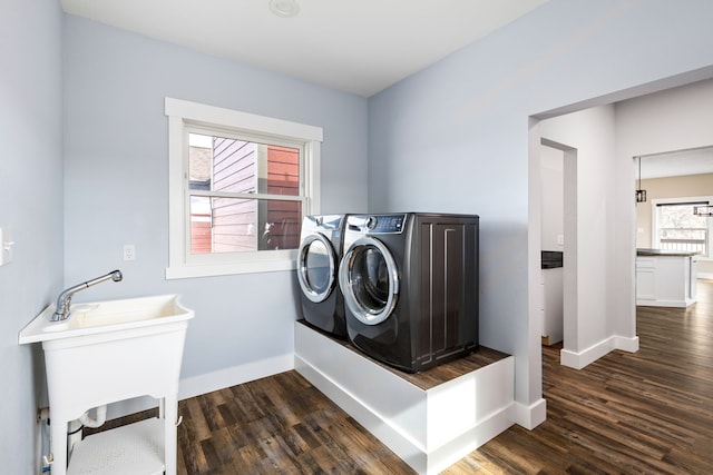 clothes washing area with washer and dryer, sink, and dark hardwood / wood-style floors