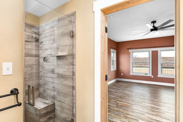 bathroom featuring hardwood / wood-style flooring, a shower with door, and ceiling fan