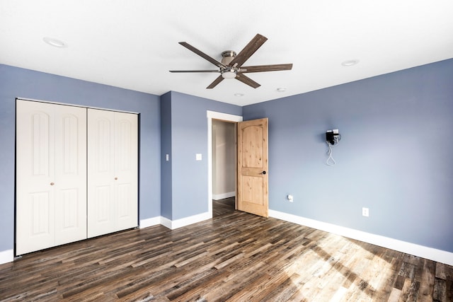 unfurnished bedroom featuring dark hardwood / wood-style floors, ceiling fan, and a closet