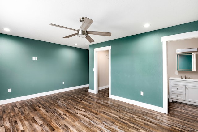 unfurnished bedroom with ceiling fan, ensuite bathroom, dark hardwood / wood-style floors, and sink