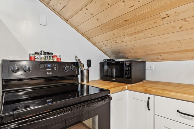 kitchen featuring sink, wooden counters, white cabinetry, black fridge, and light wood-type flooring