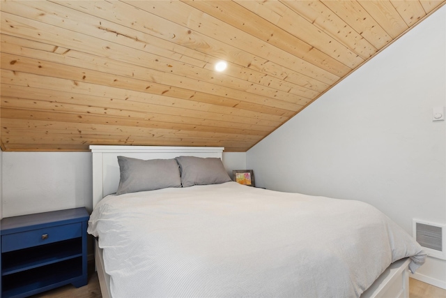 bedroom with lofted ceiling, wood ceiling, visible vents, and wood finished floors