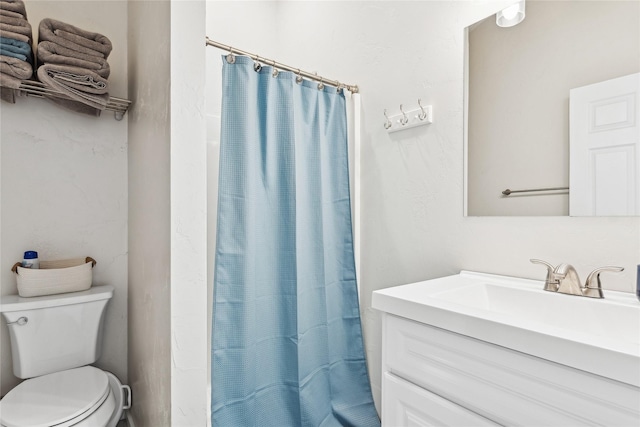 bathroom featuring curtained shower, vanity, and toilet