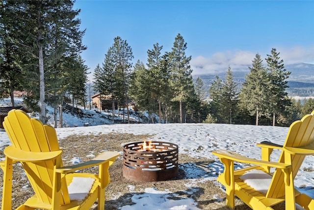 snow covered patio with an outdoor fire pit