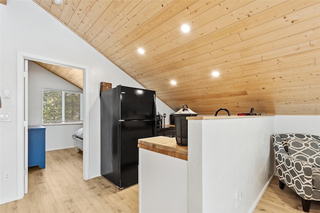 kitchen featuring wooden counters, vaulted ceiling, wooden ceiling, black refrigerator, and light wood-type flooring