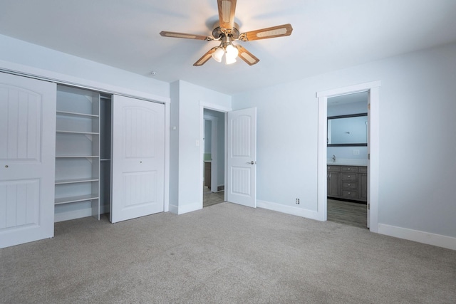 unfurnished bedroom featuring light carpet, a closet, ceiling fan, and ensuite bathroom