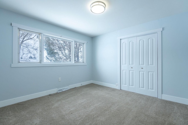 unfurnished bedroom featuring carpet floors and a closet