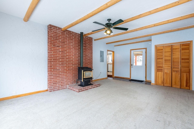 unfurnished living room with light carpet, electric panel, beamed ceiling, and a wood stove