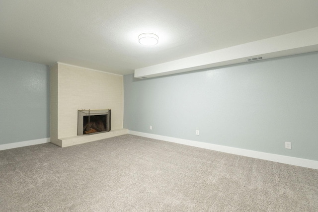 basement featuring a brick fireplace and carpet flooring