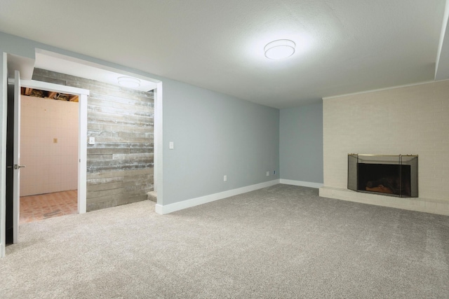 unfurnished living room with a fireplace and carpet