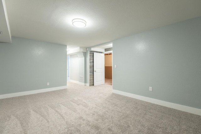 carpeted empty room featuring a textured ceiling